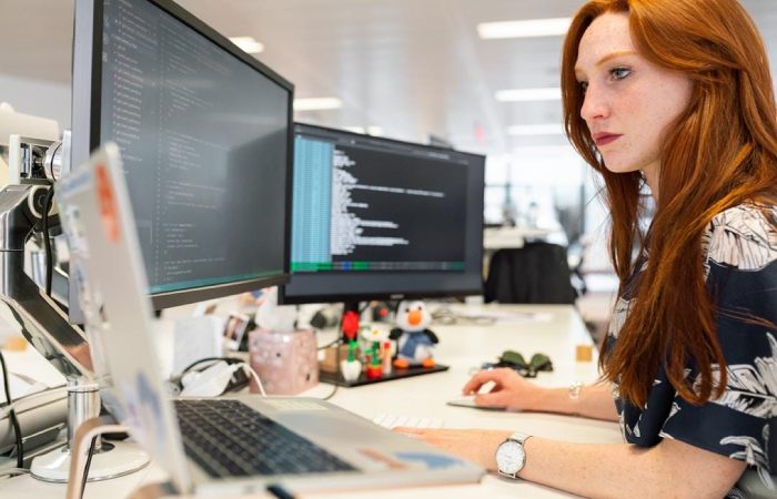 A woman in an office researching sales enablement tools on her computer